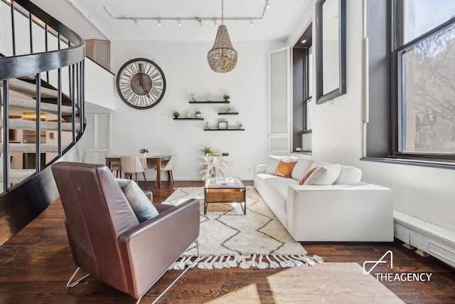 living room with track lighting, stairs, and wood finished floors