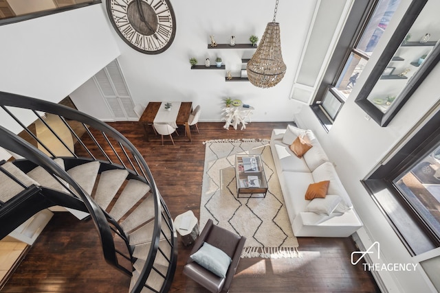 living room with stairs, hardwood / wood-style flooring, and baseboards