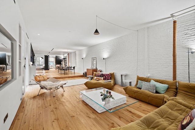 living room with hardwood / wood-style flooring and brick wall