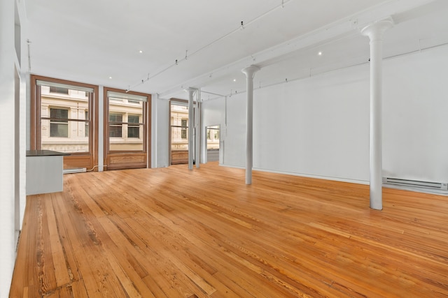 interior space with a baseboard heating unit, hardwood / wood-style floors, and a baseboard radiator