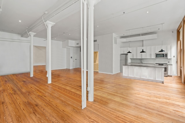 below grade area featuring light wood-type flooring and freestanding refrigerator