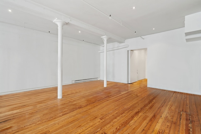 below grade area featuring wood-type flooring and a baseboard radiator