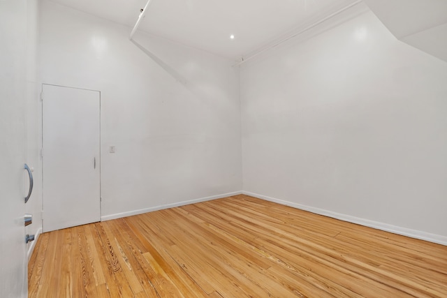 spare room with baseboards and light wood finished floors