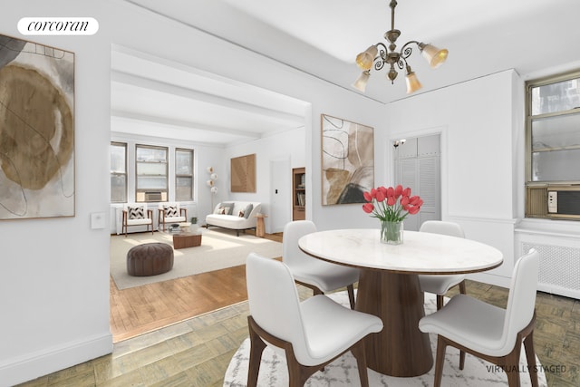 dining space featuring visible vents, a notable chandelier, radiator heating unit, baseboards, and parquet flooring