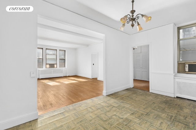 71 Park Ave Unit 3C, New York City, NY 10016 - unfurnished dining area with a chandelier, healthy amount of natural light, radiator heating unit, and baseboards
