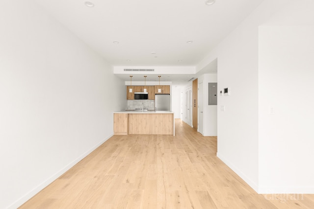 unfurnished living room with visible vents, baseboards, light wood-type flooring, recessed lighting, and a sink