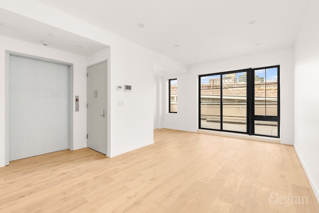 unfurnished room with baseboards and light wood finished floors