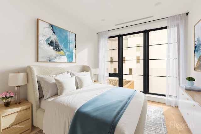 bedroom with light wood-style flooring and vaulted ceiling