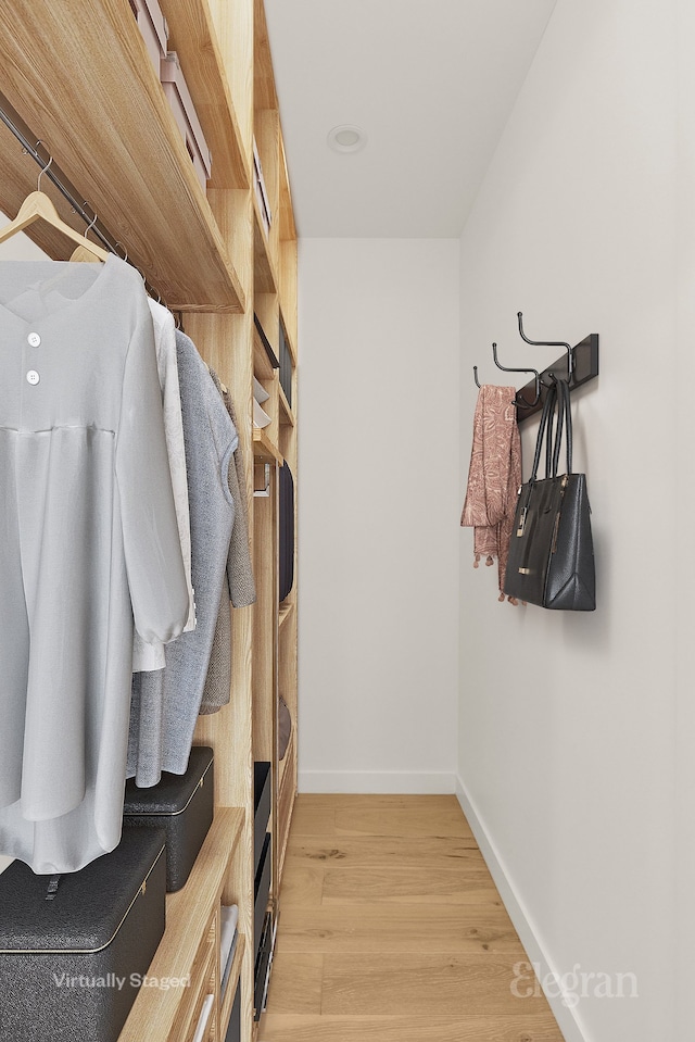 walk in closet with light wood-style flooring
