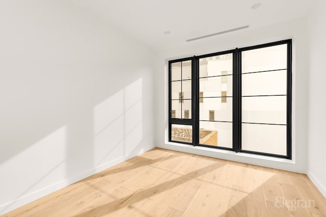 unfurnished room with baseboards and wood finished floors
