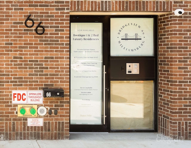 doorway to property featuring brick siding