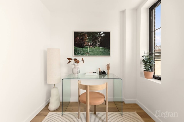 home office with baseboards and wood finished floors