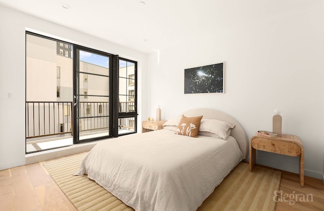 bedroom with baseboards, access to outside, and wood finished floors