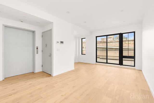 unfurnished room featuring light wood-style flooring and baseboards