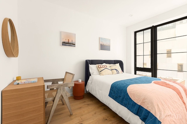 bedroom with light wood-style floors and baseboards