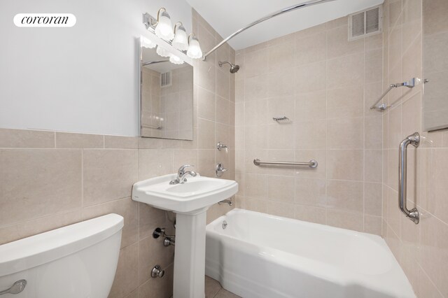 bathroom featuring visible vents, toilet, tile walls, and shower / bath combination