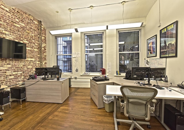 home office featuring wood finished floors and brick wall