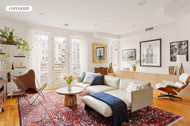 living area with visible vents, recessed lighting, and light wood-type flooring