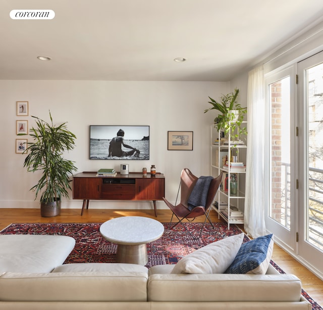 living area featuring recessed lighting, wood finished floors, visible vents, and baseboards