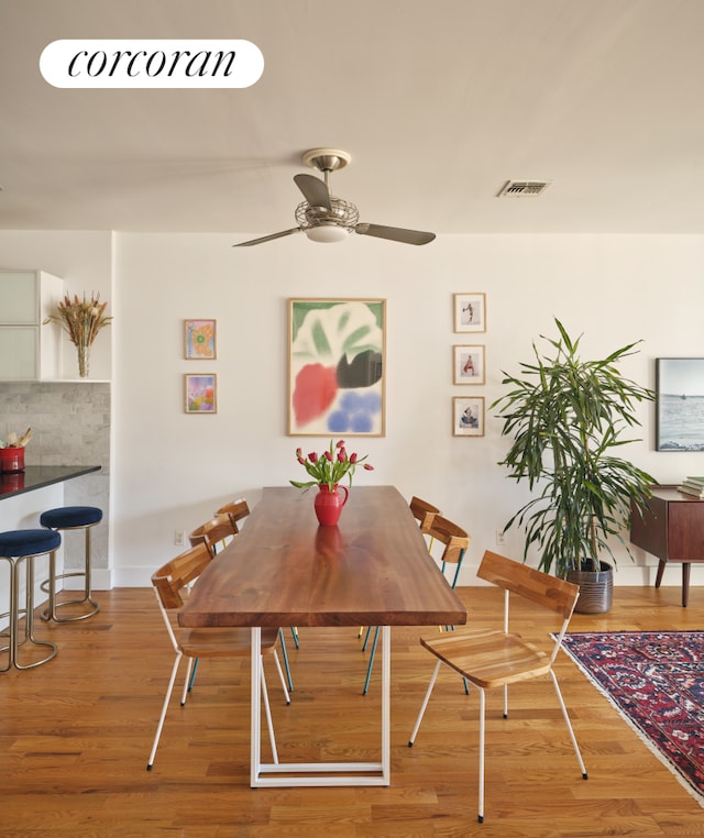 dining space with visible vents, wood finished floors, and a ceiling fan