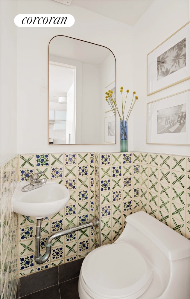 bathroom featuring wainscoting, toilet, and tile walls