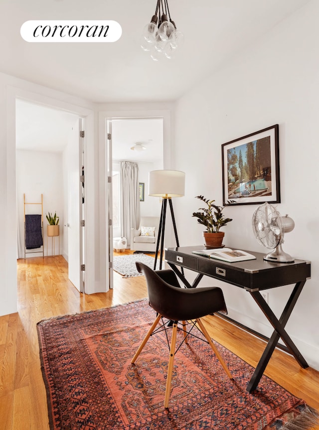 office space with light wood-style flooring and a chandelier