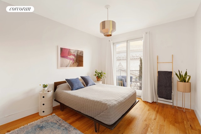 bedroom featuring access to outside, light wood-style floors, visible vents, and baseboards