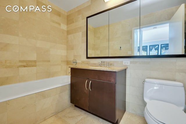 full bathroom featuring a relaxing tiled tub, marble finish floor, tile walls, and vanity