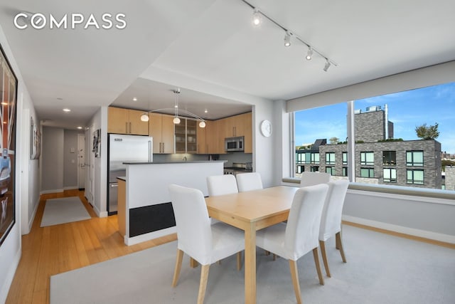 dining area featuring recessed lighting, light wood-type flooring, and baseboards