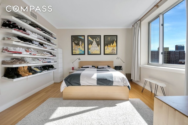 bedroom featuring visible vents, baseboards, and light wood-style floors