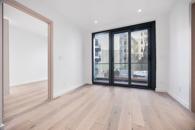 empty room with recessed lighting, baseboards, and light wood-style flooring