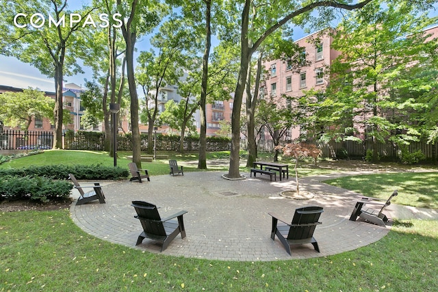 view of community with a patio area, a lawn, and fence