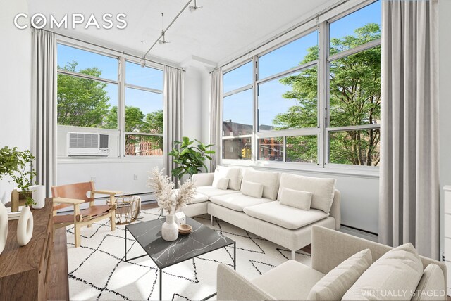 sunroom featuring baseboard heating and cooling unit