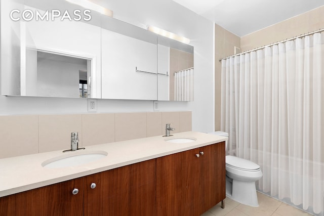 full bathroom with double vanity, tile patterned floors, toilet, and backsplash