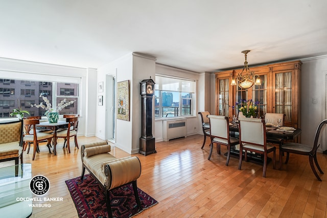 50 Sutton Pl S Unit 14G, New York City, NY 10022 - dining space with radiator, light wood-type flooring, and a chandelier