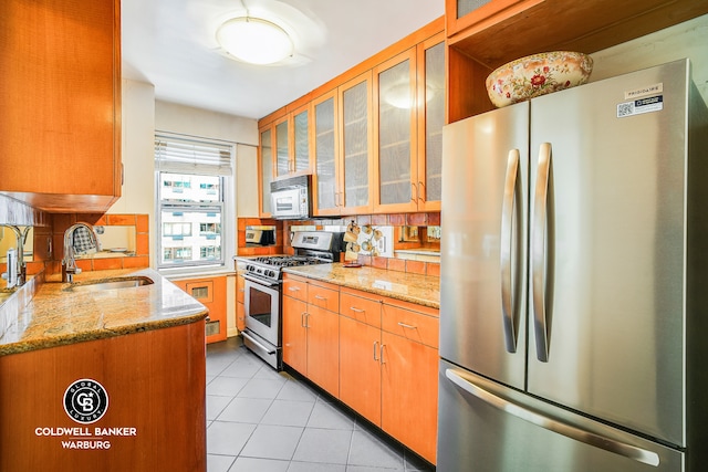 50 Sutton Pl S Unit 14G, New York City, NY 10022 - kitchen with stainless steel appliances, a sink, light tile patterned flooring, decorative backsplash, and light stone counters