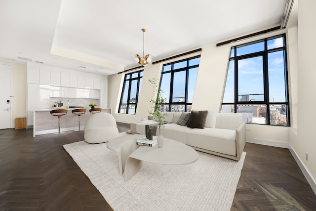 living area featuring an inviting chandelier and baseboards