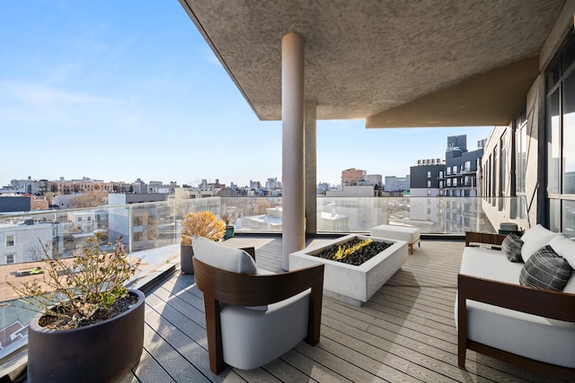 wooden terrace with a view of city and an outdoor living space with a fire pit