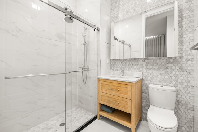 full bath featuring vanity, toilet, and a marble finish shower