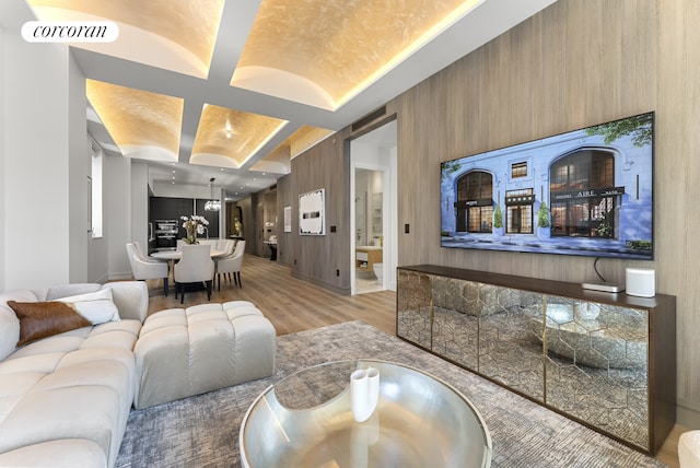 living room featuring visible vents, beamed ceiling, coffered ceiling, and light wood-type flooring