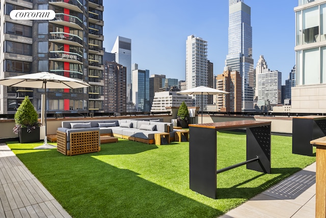 view of home's community with a view of skyline, a lawn, and an outdoor hangout area