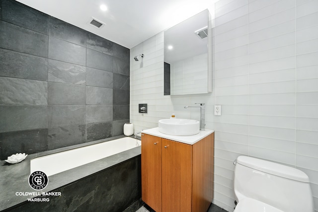 full bath with tile walls, a bath, vanity, and toilet