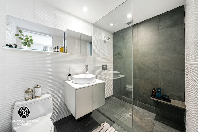 bathroom with toilet, walk in shower, tile walls, vanity, and recessed lighting