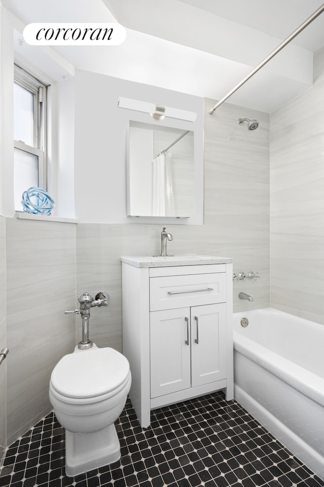 bathroom with vanity, tile walls, toilet, and shower / bath combo with shower curtain