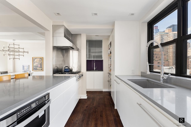 kitchen with visible vents, dark wood-type flooring, a sink, custom exhaust hood, and stainless steel gas cooktop