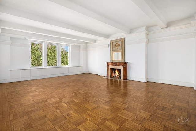 unfurnished living room with beamed ceiling, baseboards, and a high end fireplace
