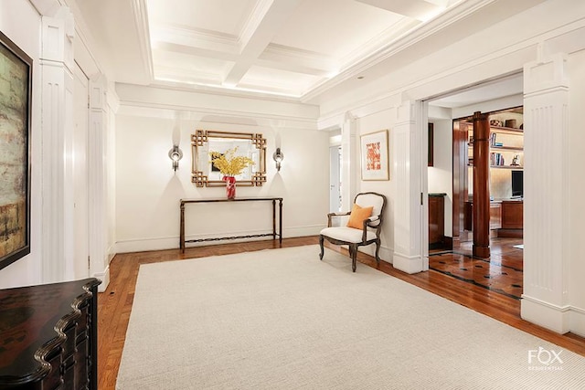 living area featuring crown molding, decorative columns, beamed ceiling, hardwood / wood-style flooring, and coffered ceiling