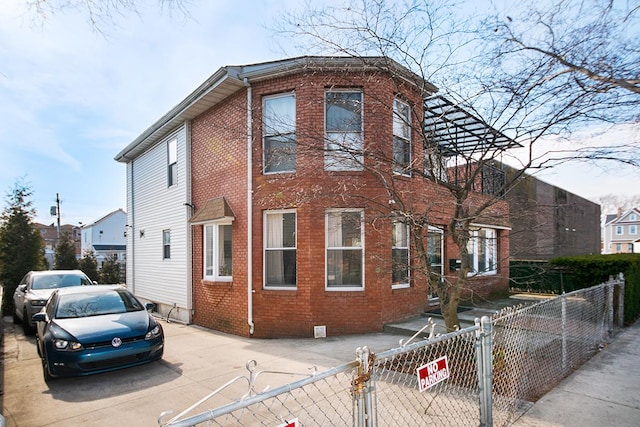 view of front of home featuring a fenced front yard, brick siding, and a gate