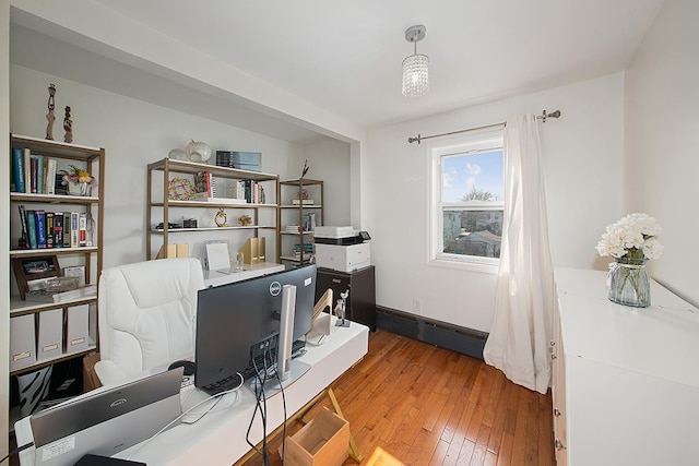 home office featuring baseboard heating, baseboards, and hardwood / wood-style floors