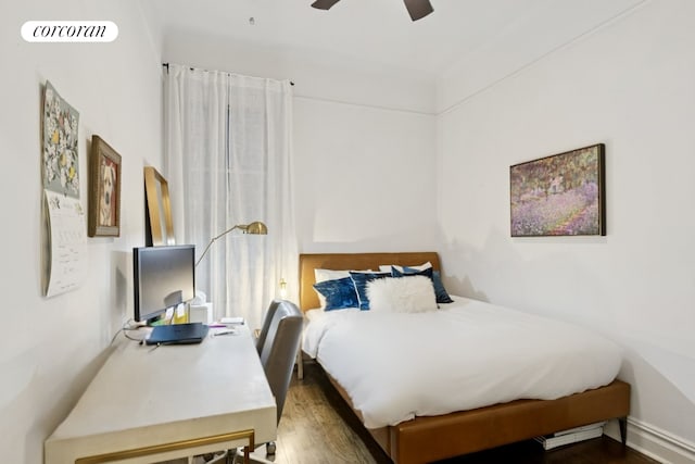 bedroom with a ceiling fan, wood finished floors, visible vents, and baseboards